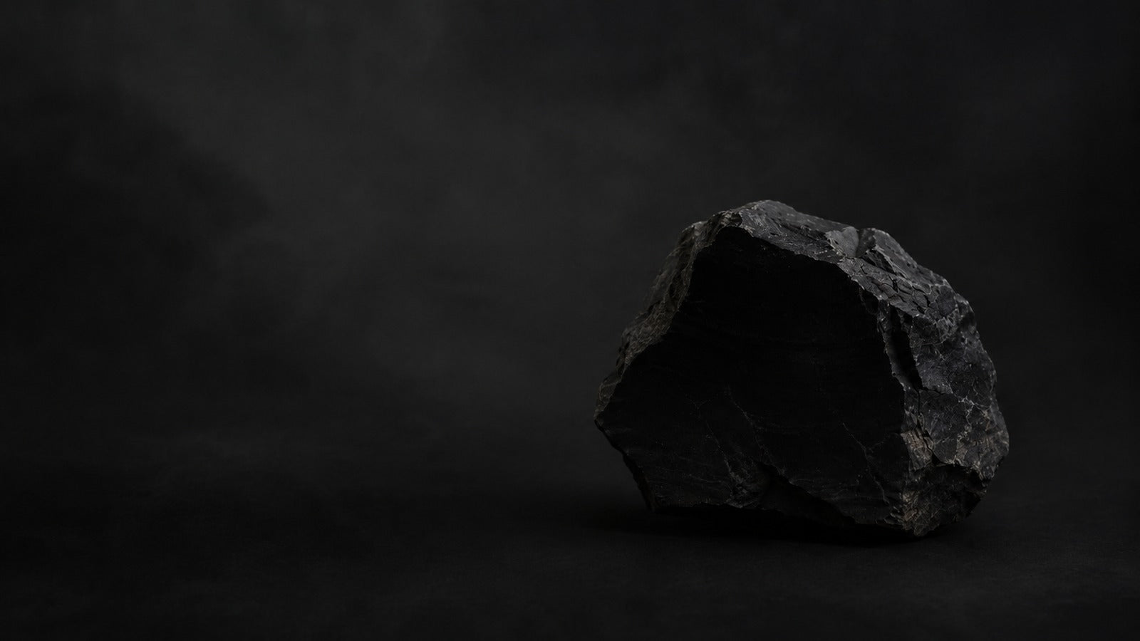 Raw black onyx stone with a dark polished mineral surface