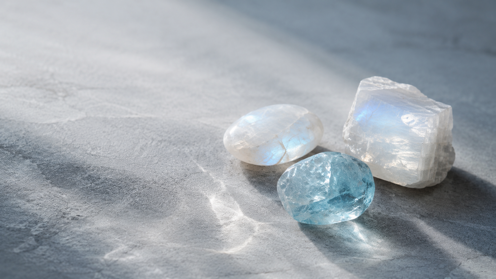 Pale reflective stones on cool mineral surface for Pisces jewelry mood