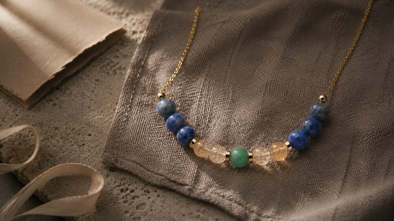 Natural stone zodiac necklace on tactile linen for L&H Atelier meaningful jewelry gifts Journal cover